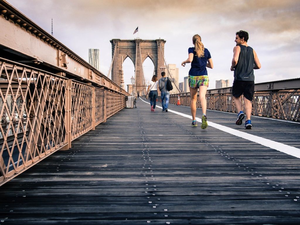 individuals running on a bridge