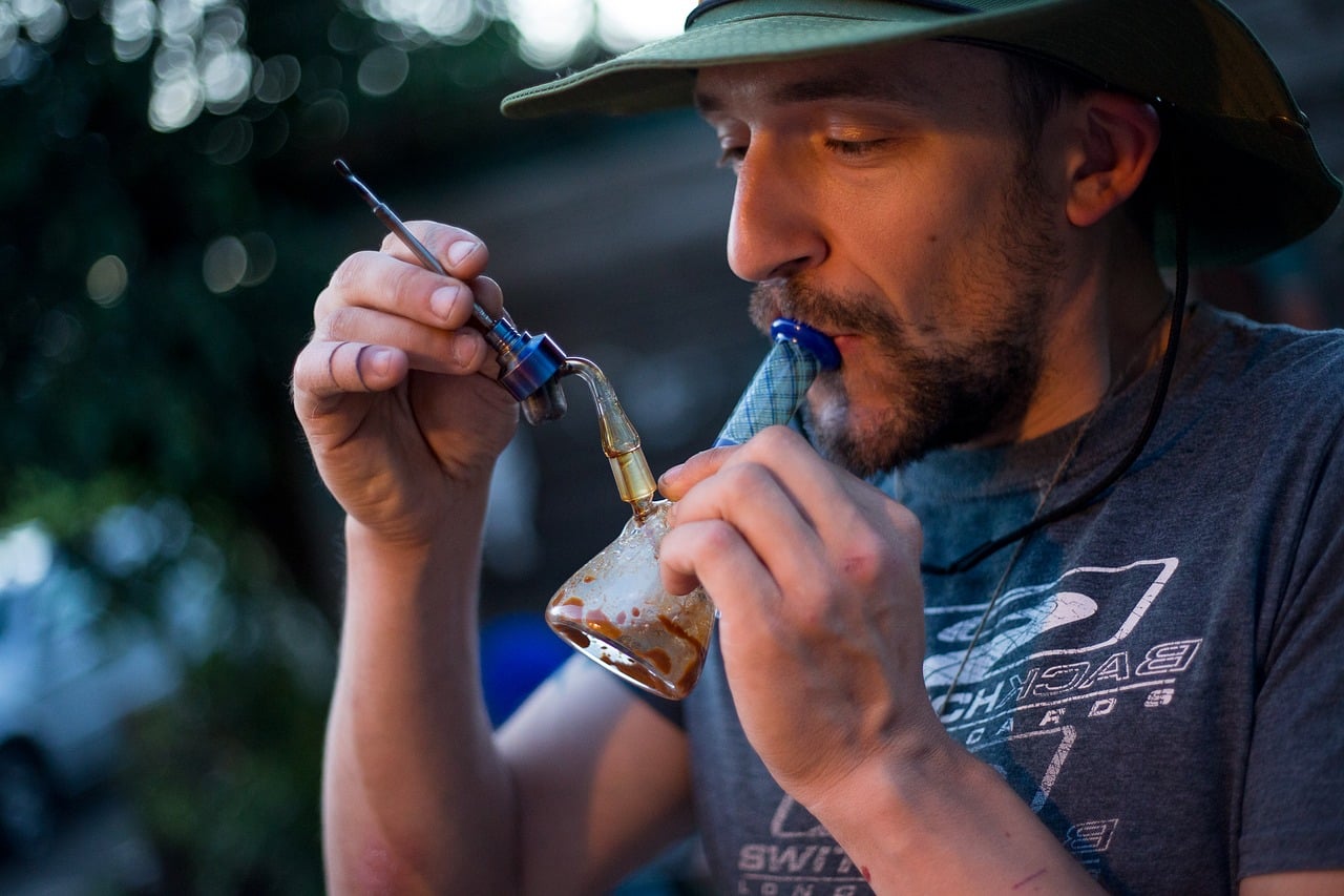 a man dabbing marijuana concentrate outside