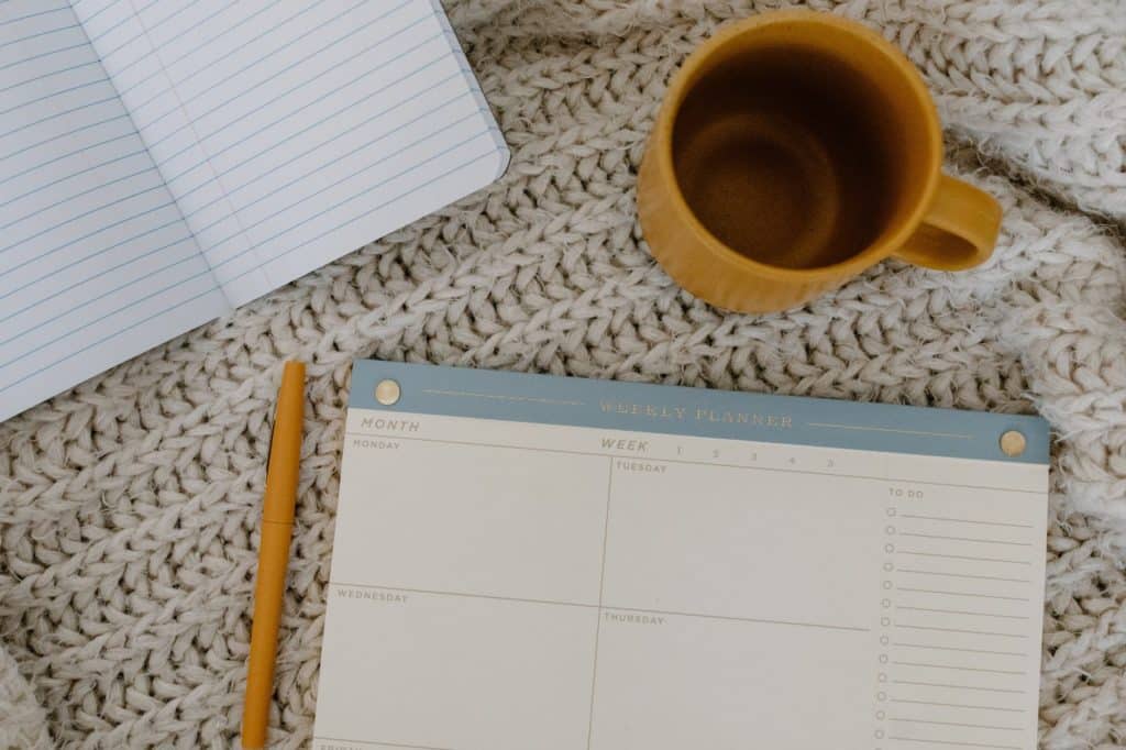 calendar, notes and a yellow coffee mug